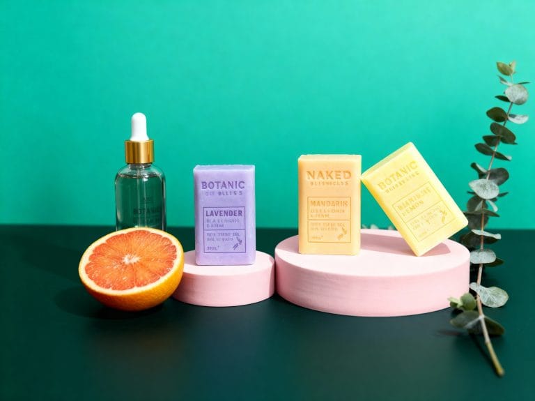 Skincare serum and packaging on pink podiums against a teal backdrop – skincare product shot